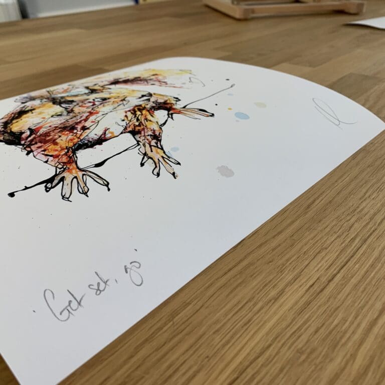 Photograph of Get Set, Go! by Kathryn Callaghan, a print of an energetic red squirrel, which shows the print's title handwritten in the bottom left corner and the artist's signature in the bottom right, with space between to add a custom personalisation.