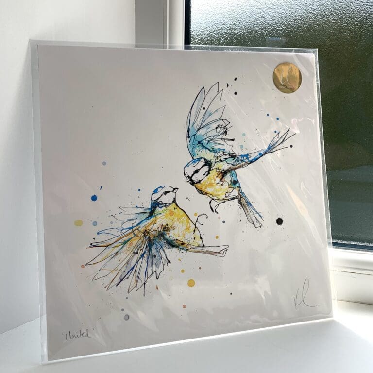 A print of United by Kathryn Callaghan, which features a pair of blue tits in flight. The 30cm print is presented flat in a clear cello bag with a golden KC sticker in the top right.