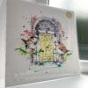 A print of Dublin Doors by Kathryn Callaghan, which features the iconic Georgian style doors of the city with a pair of house sparrows perched in the foreground. The 30cm print is presented flat in a clear cello bag with a golden KC sticker in the top right.