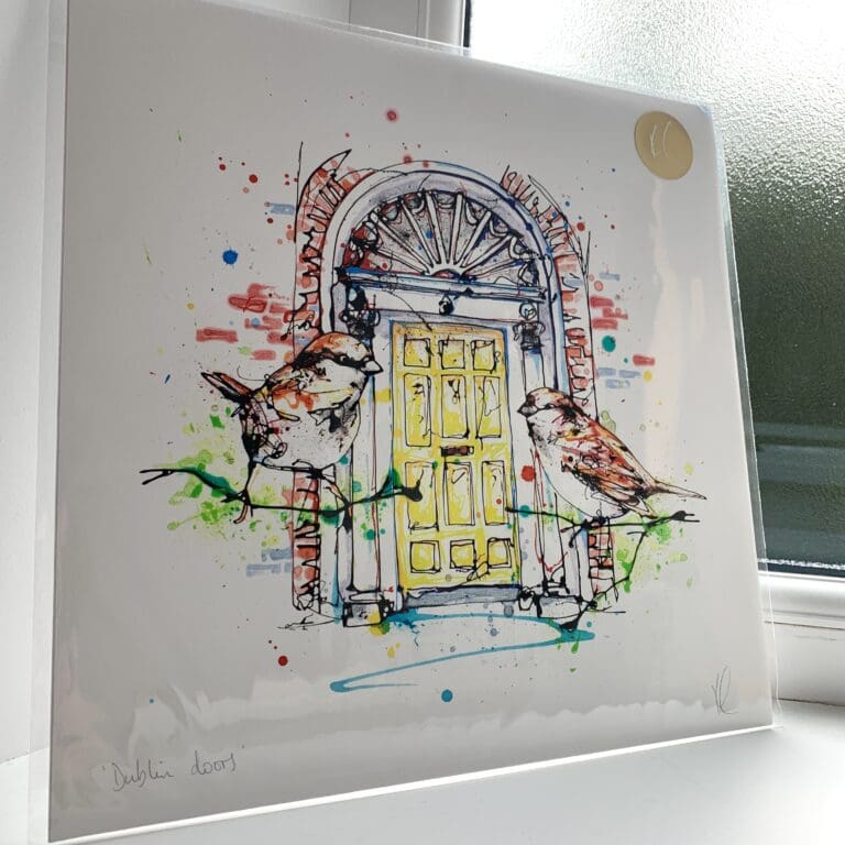 A print of Dublin Doors by Kathryn Callaghan, which features the iconic Georgian style doors of the city with a pair of house sparrows perched in the foreground. The 30cm print is presented flat in a clear cello bag with a golden KC sticker in the top right.