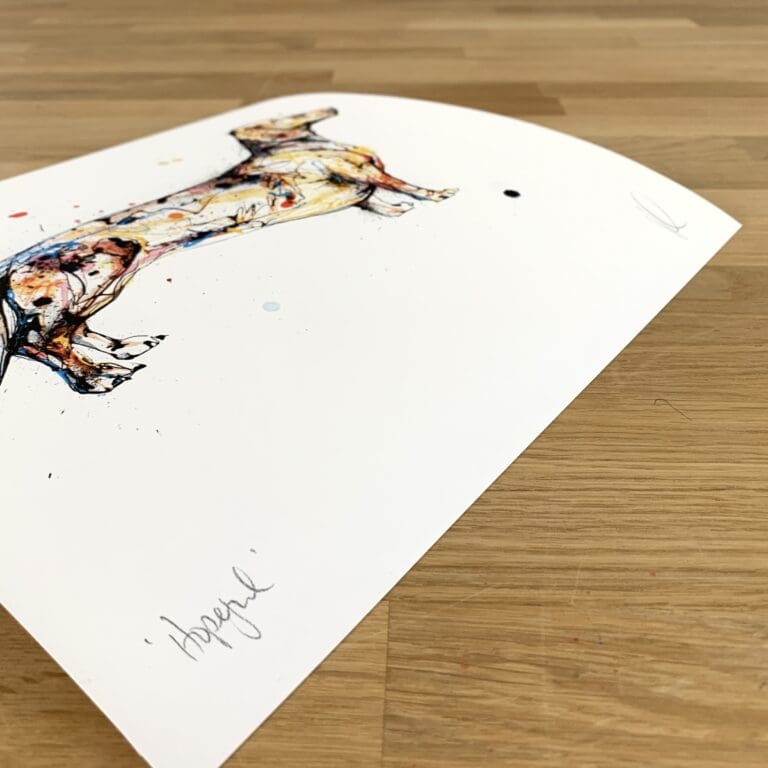 Photograph of Hopeful by Kathryn Callaghan, a print of a standing dachshund facing right, which shows the print's title handwritten in the bottom left corner and the artist's signature in the bottom right, with space between to add a custom personalisation.