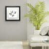 Belonging Four Swallows Print shown in Deluxe Black Frame in Situ alongside houseplant