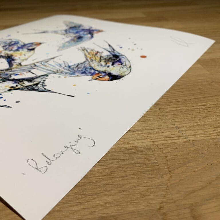 Photograph of Belonging, a print of four swallows flying in a loop by Kathryn Callaghan, which shows the print's title handwritten in the bottom left corner and the artist's signature in the bottom right, with space between to add a custom personalisation.