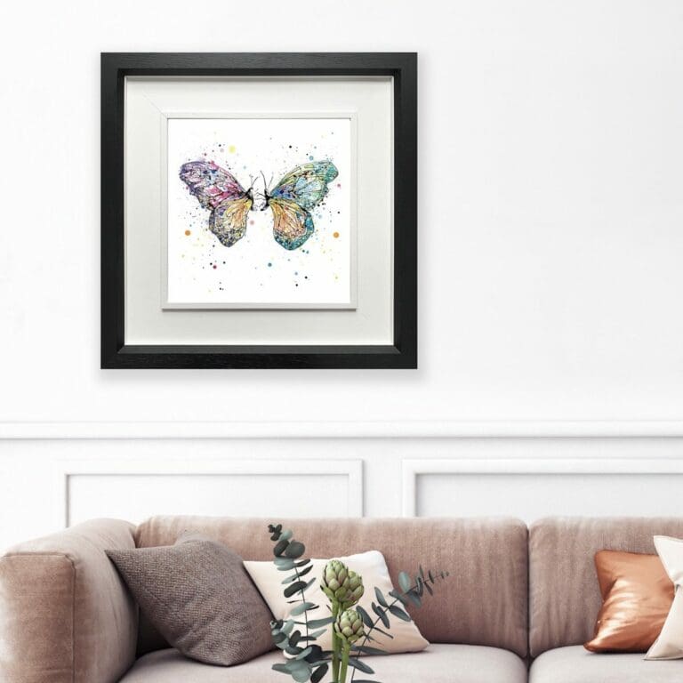 Destiny Butterfly Print shown in Deluxe Black Frame in Situ above pink sofa