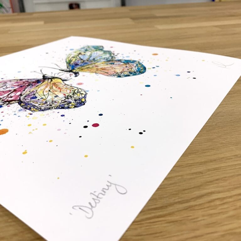 Photograph of Destiny, a print of two colourful butterflies by Kathryn Callaghan, which shows the print's title handwritten in the bottom left corner and the artist's signature in the bottom right, with space between to add a custom personalisation.