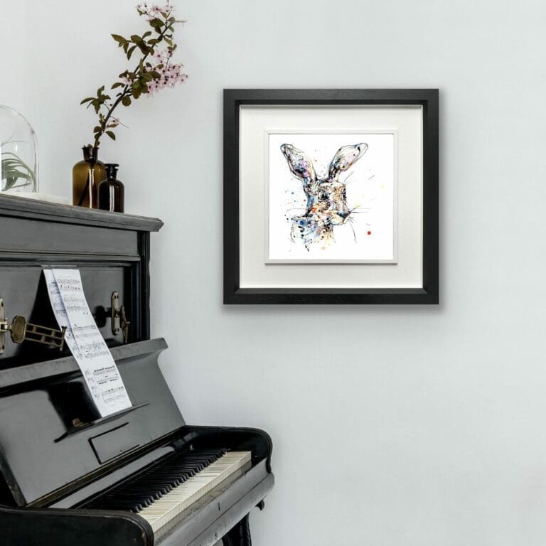 Hartley Hare Print shown in Deluxe Black Frame in Situ alongside black piano