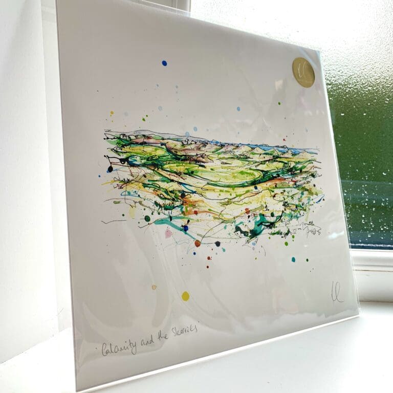 A print of Calamity and the Skerries by Kathryn Callaghan, which portrays the view from the 16th hole of Royal Portrush Golf Club. The 30cm print is presented flat in a clear cello bag with a golden KC sticker in the top right.