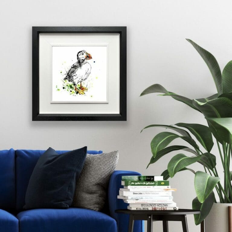 Atlantic puffin Print shown in Deluxe Black Frame in Situ beside houseplant