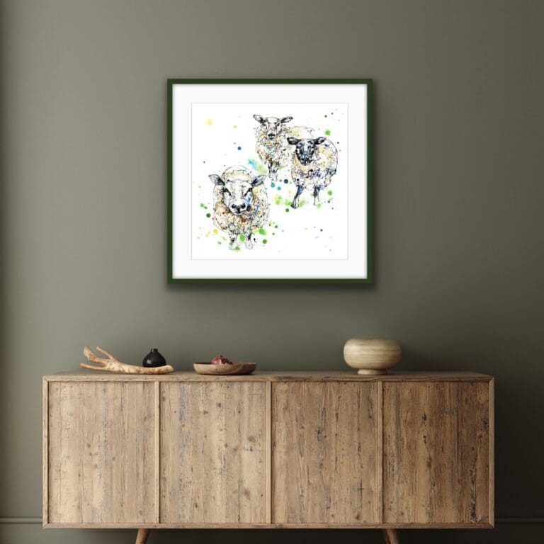 All Ears Sheep Print shown in black frame in situ above a wood sideboard