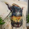 Close up of a canvas bucket bag featuring a painting of a bee called Buzz by Kathryn Callaghan.