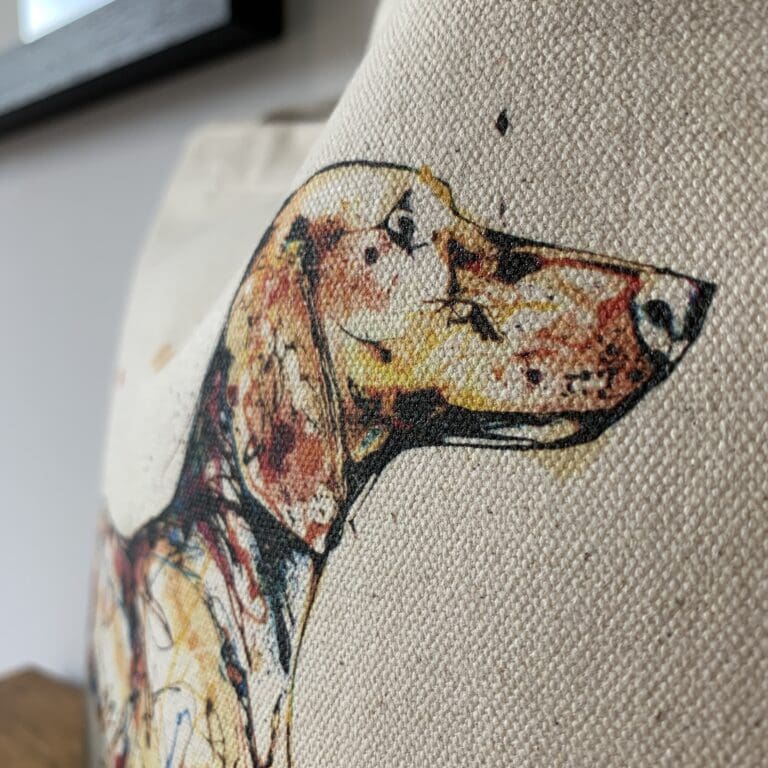 Close up of a canvas bucket bag featuring a painting of a dachshund named Hopeful by Kathryn Callaghan.