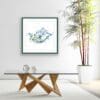 Splash swimming dolphins print by Northern Ireland artist Kathryn Callaghan shown framed in situ in a white room with leafy bamboo.