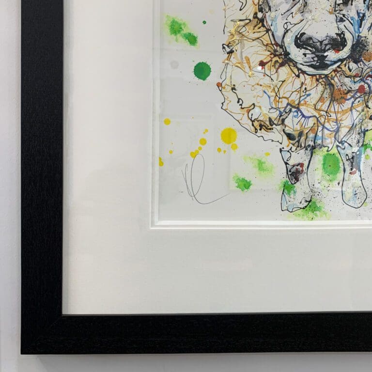 Close up showing Kathryn Callaghan's signature and the black wooden frame and white double mount of All Ears, original sheep painting.