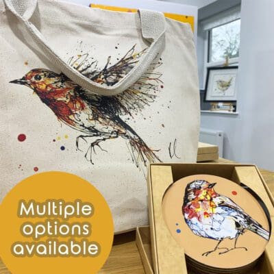 A canvas bucket bag featuring a print of a flying robin by Kathryn Callaghan sits alongside a set of coasters in a brown box. The top coaster also features a robin print by Kathryn Callaghan on an orange background. Digital text reads "Multiple options available".