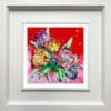 Love, a print of pink, orange, and magenta tulips against a vibrant red background by Kathryn Callaghan, shown in a deluxe white frame.