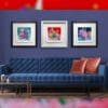 Love shown in a Deluxe White Frame alongside Peace in a Deluxe Black Frame and Understanding in a Deluxe Black Frame in situ in a blue sitting room