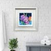 Understanding shown in a Deluxe White Frame on an exposed white brick wall above a blue sideboard with rolled up towels