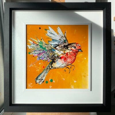 An original painting by Kathryn Callaghan, titled 'Flight High'. The painting features a robin in flight against a vibrant golden yellow background and is framed in a two-part white and black frame.