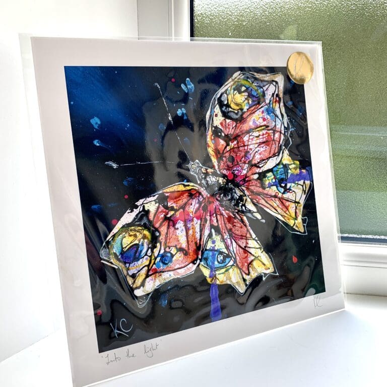 A print of Into the Light by Kathryn Callaghan, which features an abstract peacock butterfly against a deep blue background. The 30cm print is presented flat in a clear cello bag with a golden KC sticker in the top right.