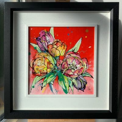 An original painting by Kathryn Callaghan, titled 'Love'. The painting features a posy of red, orange and purple tulips against a vibrant red background and is framed in a two-part white and black frame.