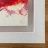 A close up photograph of the pencil signature and thick white floating tray frame surrounding Passion, an original abstract painting by Kathryn Callaghan.