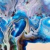 A close up photograph showing the intricate organic detail of reacting blue, pink, green, gold and white paints present on Revival, an original abstract painting by Kathryn Callaghan.