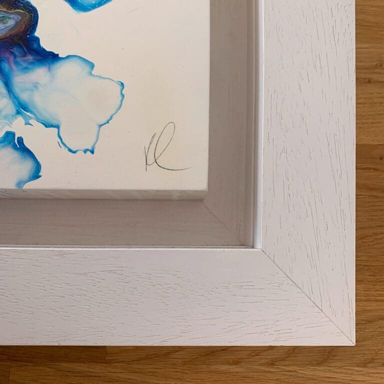 A close up photograph of the pencil signature and thick white floating tray frame surrounding Revival, an original abstract painting by Kathryn Callaghan.