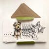 The contents of a set of miniature notecards featuring two designs by Kathryn Callaghan: Expectation, which shows a terrier, and Dreamer, which shows a sleeping cat. There are four of each notecard shown with two of their accompanying envelopes.