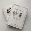The reverse of a set of notecards featuring artwork of a sleeping cat named Dreamer and a terrier named Expectation, both by Kathryn Callaghan. Text on the rear cover gives information on the cards being printed on 100% recycled card stock with renewable energy.