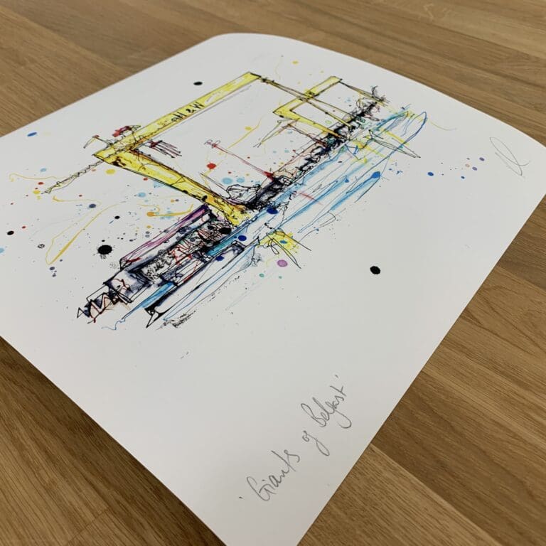 Photograph of Giants of Belfast, a print of the Belfast Harland & Wolff shipyard cranes by Kathryn Callaghan, which shows the print's title handwritten in the bottom left corner and the artist's signature in the bottom right, with space between to add a custom personalisation.