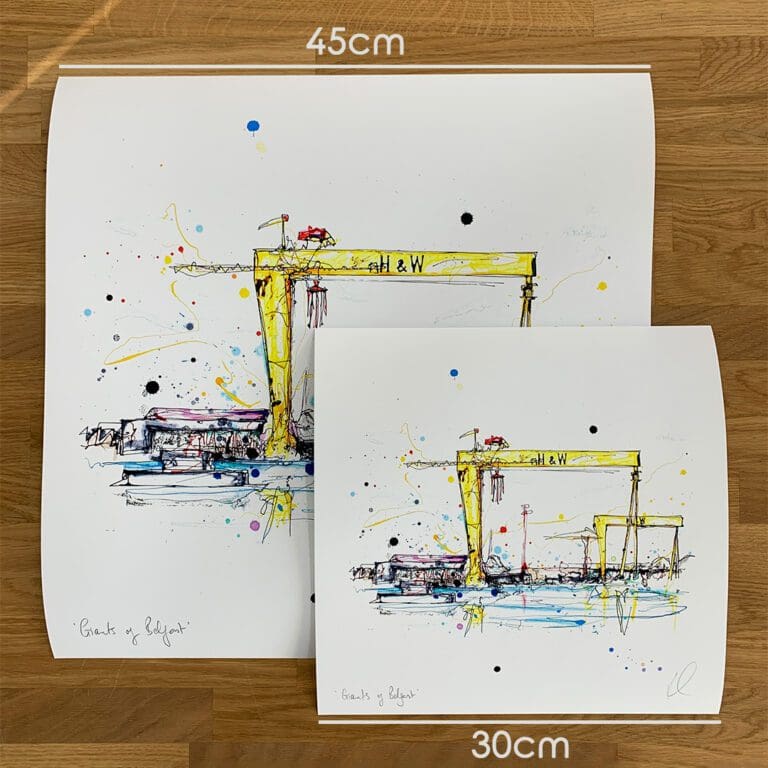 Two prints of Giants of Belfast by Kathryn Callaghan, which portrays the Belfast Harland & Wolff shipyard cranes, to show the size difference between the 45cm print and the 30cm print.