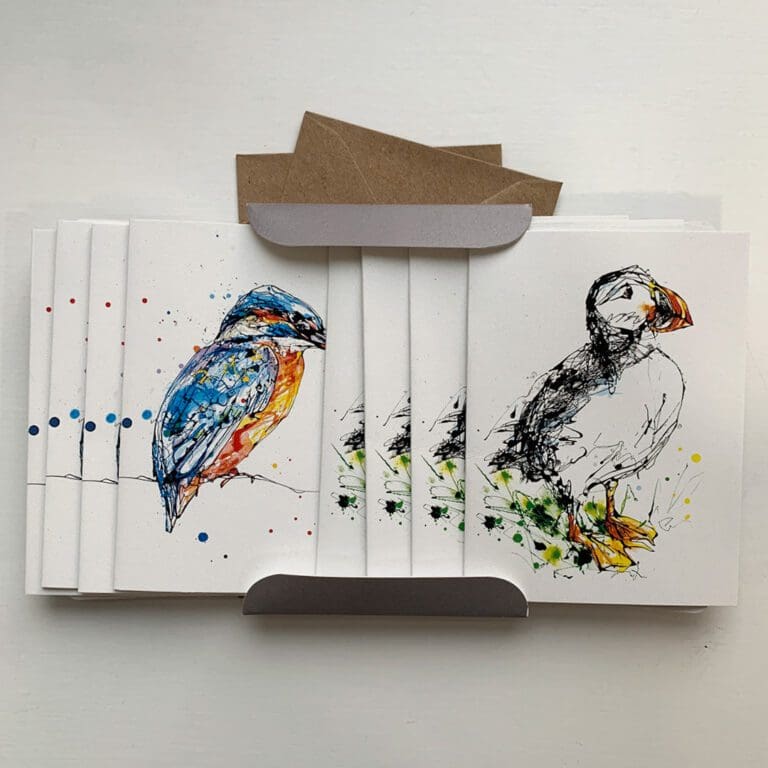 The contents of a set of miniature notecards featuring two designs by Kathryn Callaghan: Gaze, which shows a perched kingfisher, and Atlantic Puffin. There are four of each notecard shown with two of their accompanying envelopes.