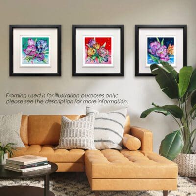 Peace Love and Understanding, three floral prints by Kathryn Callaghan, shown in Deluxe Black Frames in Situ above and behind a large tan leather sofa and a banana leaf plant.