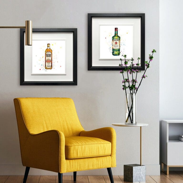 Two prints of whiskey by Kathryn Callaghan shown hung in situ in a reading nook. The prints are Bushmills Irish Whiskey and Jameson Irish Whiskey, both hung in deluxe black frames.