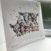 A print of Well, Hello by Kathryn Callaghan, which features three dairy cows looking over a red fence gate. The 30cm print is presented flat in a clear cello bag with a golden KC sticker in the top right.