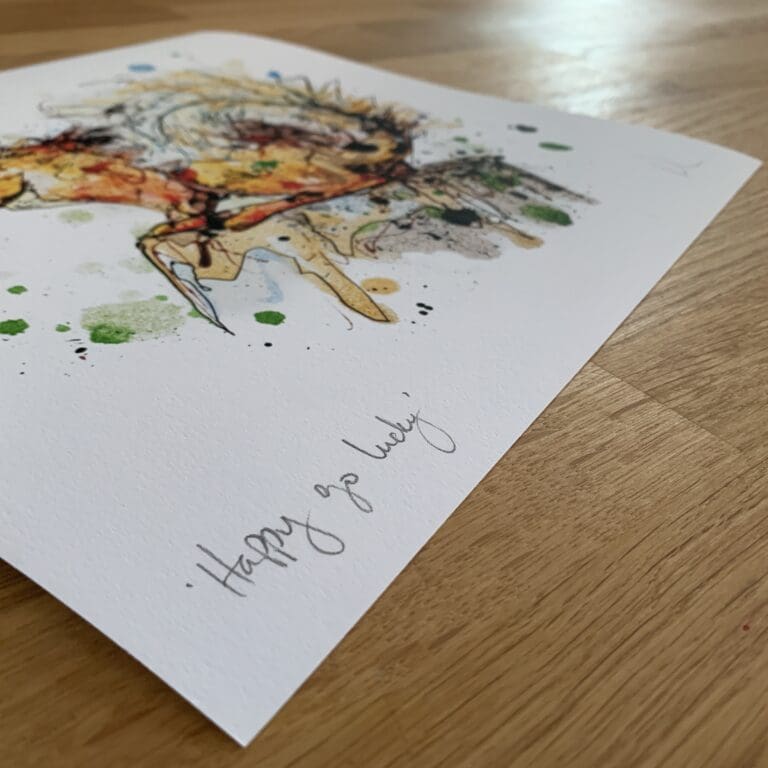 Photograph of Happy Go Lucky by Kathryn Callaghan, which shows the print's title handwritten in the bottom left corner and the artist's signature in the bottom right, with space between to add a custom personalisation.