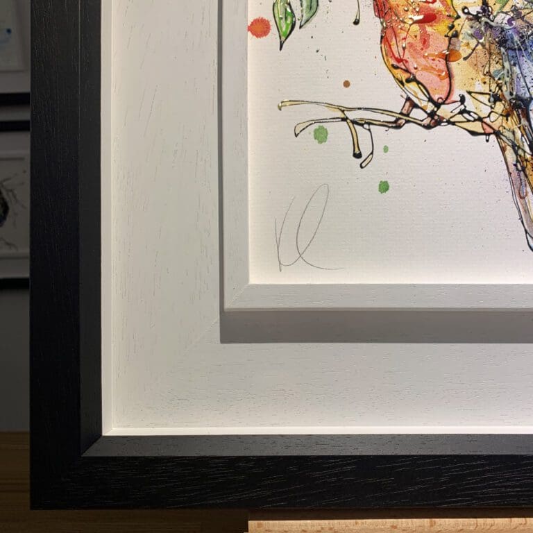 The bottom left corner of I'm Home, an original painting by Kathryn Callaghan, which shows the two part white and black wooden frame and the artist's signature on the painting.