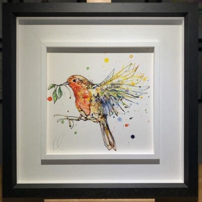 An original painting named I'm Home by Kathryn Callaghan, featuring a robin in flight with a sprig of mistletoe in its beak. The painting is framed in a two part white and black frame.