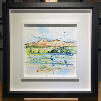 An original painting named Set Sail, Strangford Lough by Kathryn Callaghan, featuring a view from the surface of Strangford Lough to the Mournes in Northern Ireland, with sailboats on the water. The painting is framed in a two part white and black frame.