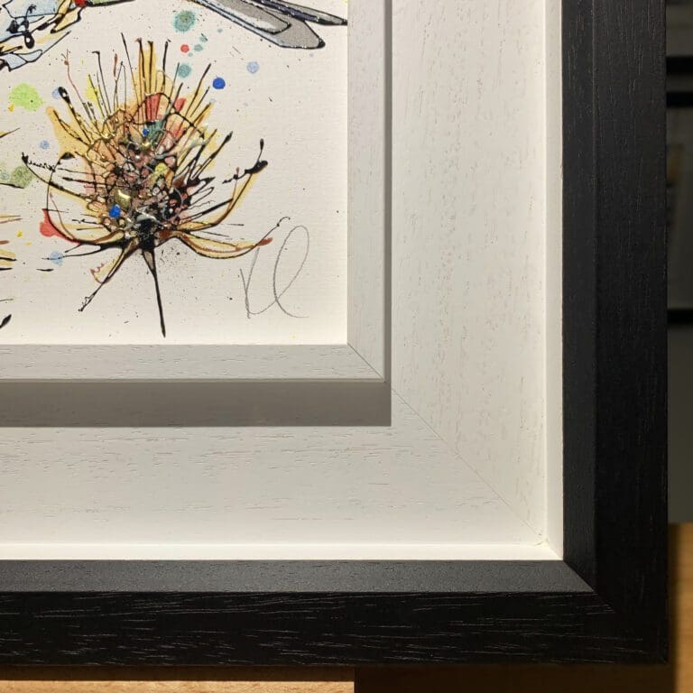 The bottom left corner of Sundown, an original painting by Kathryn Callaghan, which shows the two part white and black wooden frame and the artist's signature on the painting.