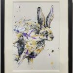 An original painting of a running hare by Kathryn Callaghan, with an off white mount and a black frame.