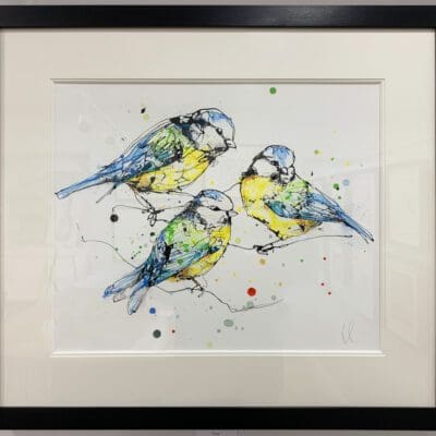 An original painting of three blue tits perched together by Kathryn Callaghan, with an off white mount and a black frame.