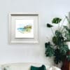 A 30x30cm print of Benone Strand by Kathryn Callaghan shown in a deluxe white fame in situ.