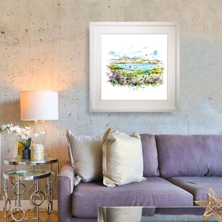 The Mournes from Murlough, a 45cm Northern Ireland Print shown in a Deluxe White Frame in Situ on a concrete wall above a lilac sofa.